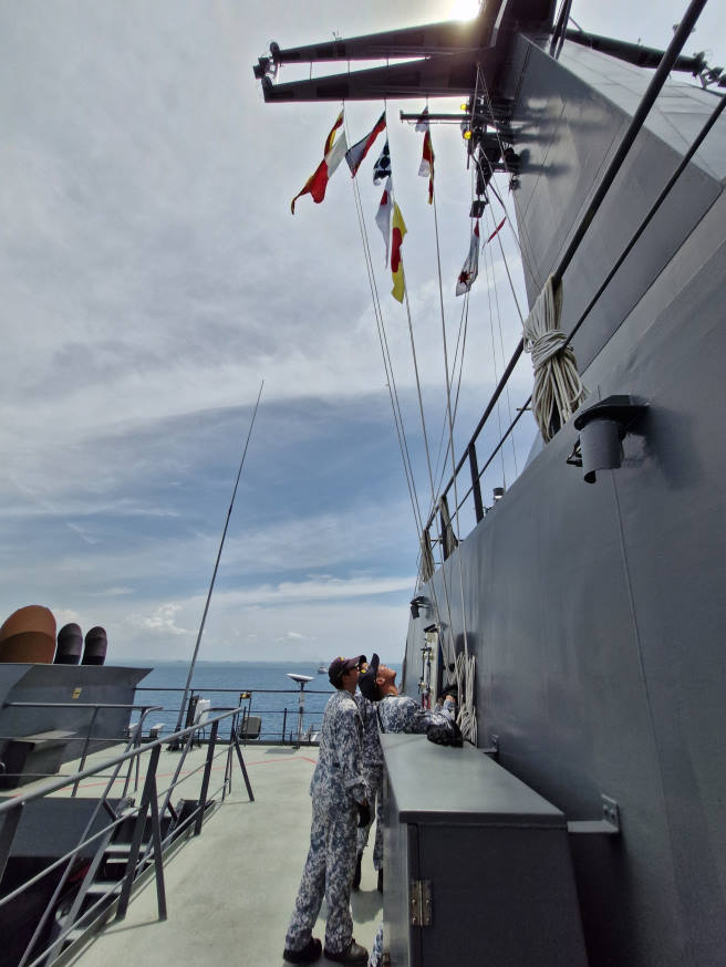 Communication Experts on board RSS Endeavour conducting a Flag Hoist as part of a communication exercise during the PASSEX.