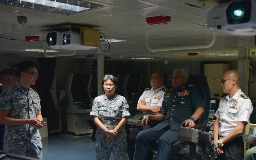 Operations Officer, Captain (CPT) Jonathan Ng briefs GEN Affendi on the ship's war-fighting capabilities.