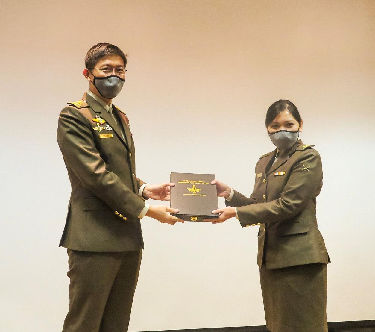 MAJ Lee Jia Hui receiving her certificate from MG Goh as the Distinguished Graduate.