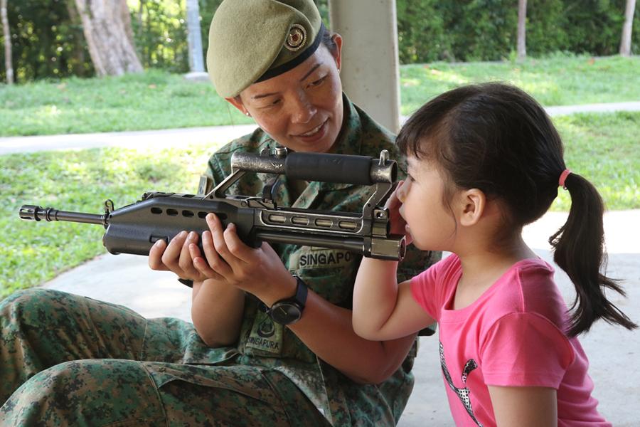 3WO Xandra showing her daughter, Iris Lee, how the Singapore Assault Rifle - 21st Century works.