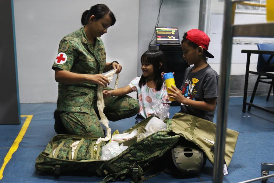 ME2 Salizah sharing with her two children what she does in her daily work as a senior medic.
