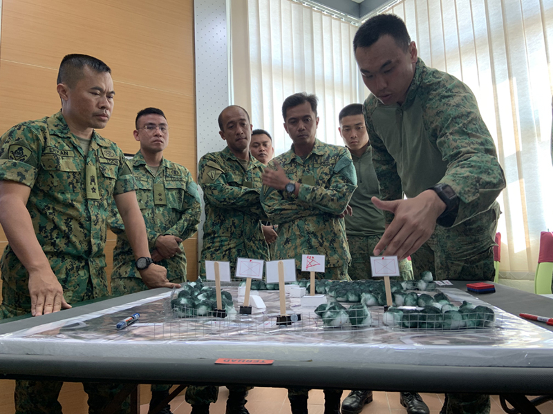 CPT Jaryl Ng (far right), Officer Commanding of Charlie Company, engaging in tabletop exercise with the officers of RBLF.