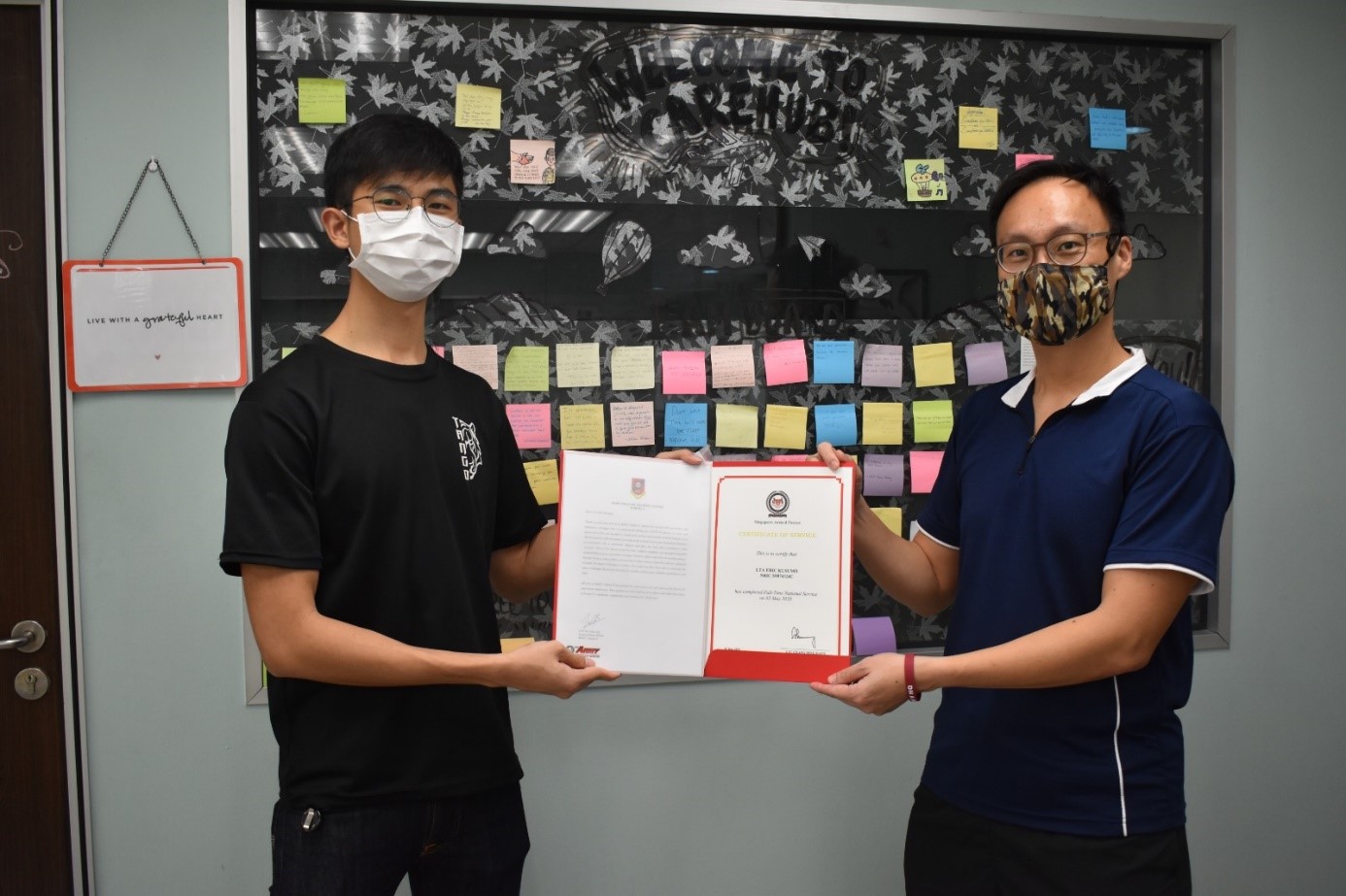 LTC Teo Chun Jin (right) presenting the ORD certificate to one of the NSF officers who has extended his service for three months to help out during COVID-19.