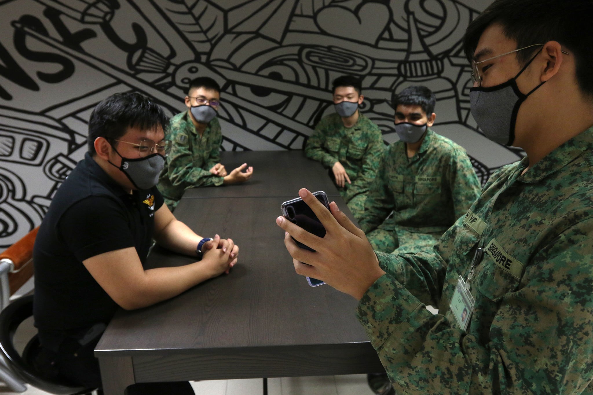 PTE Sim (bottom left) and his team having a discussion on how to further improve the IPPT application.