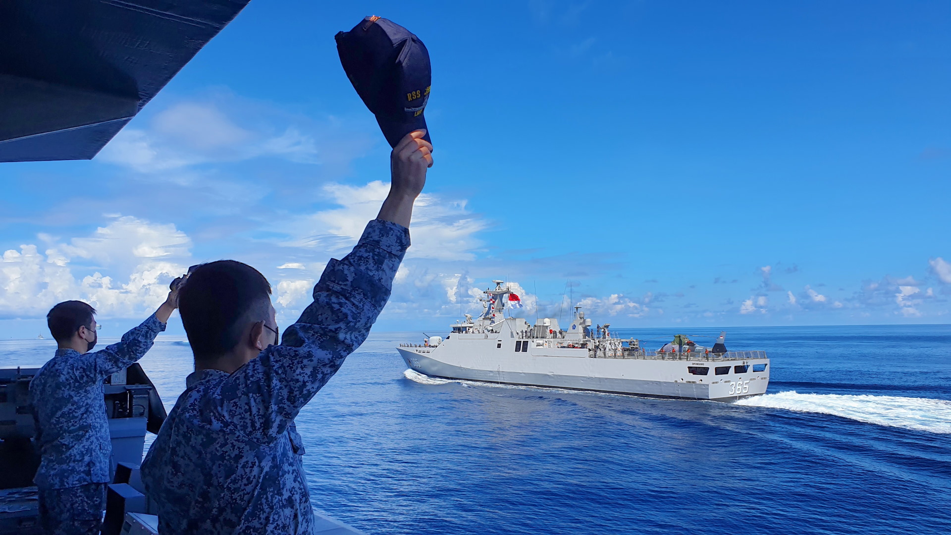 RSN sailors waving at sailors from the TNI AL to mark the conclusion of Exercise Eagle Indopura.