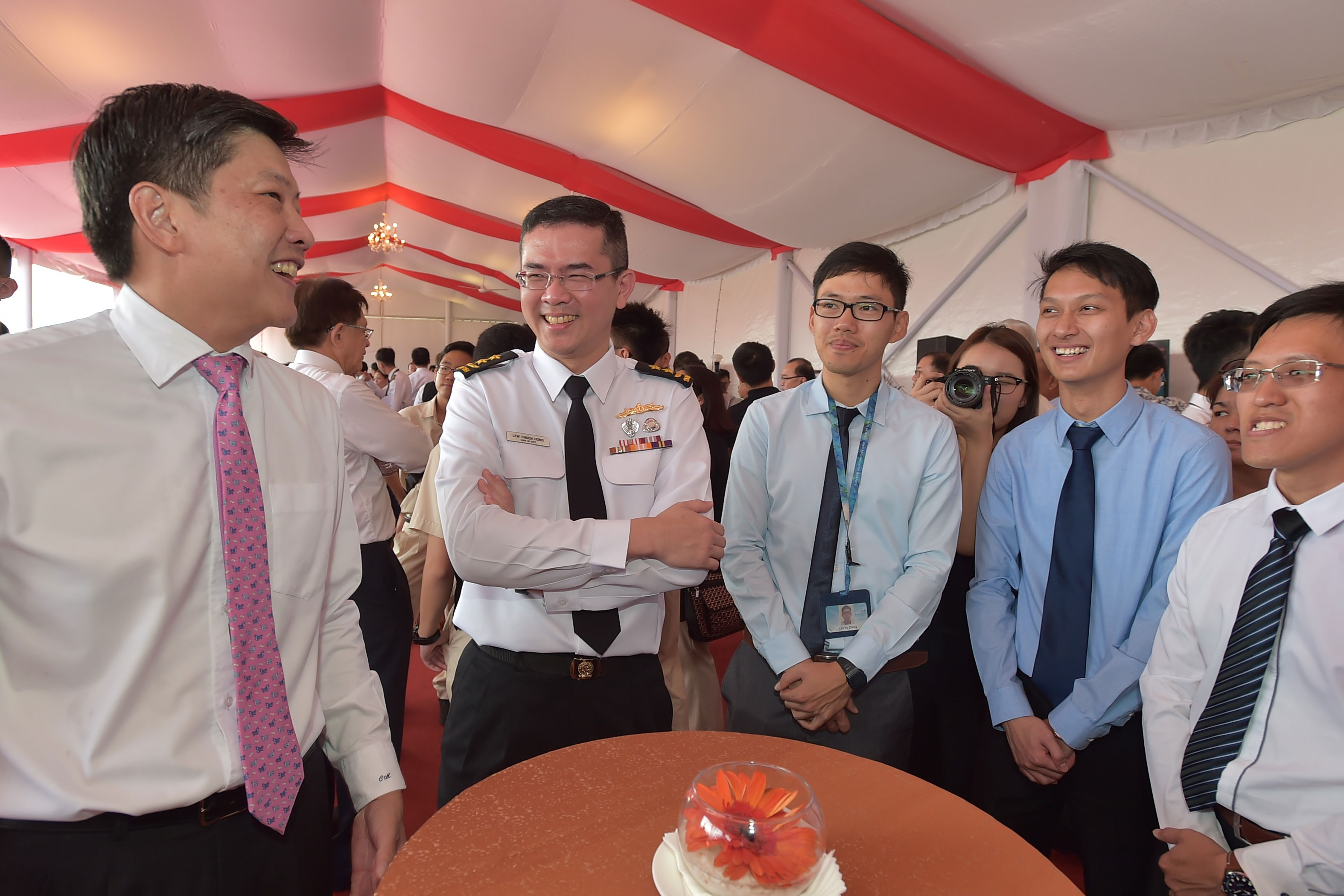 Mr Ng (left) and Chief of Navy Rear-Admiral Lew Chuen Hong interacting with representatives from Defence Science and Technology Agency.