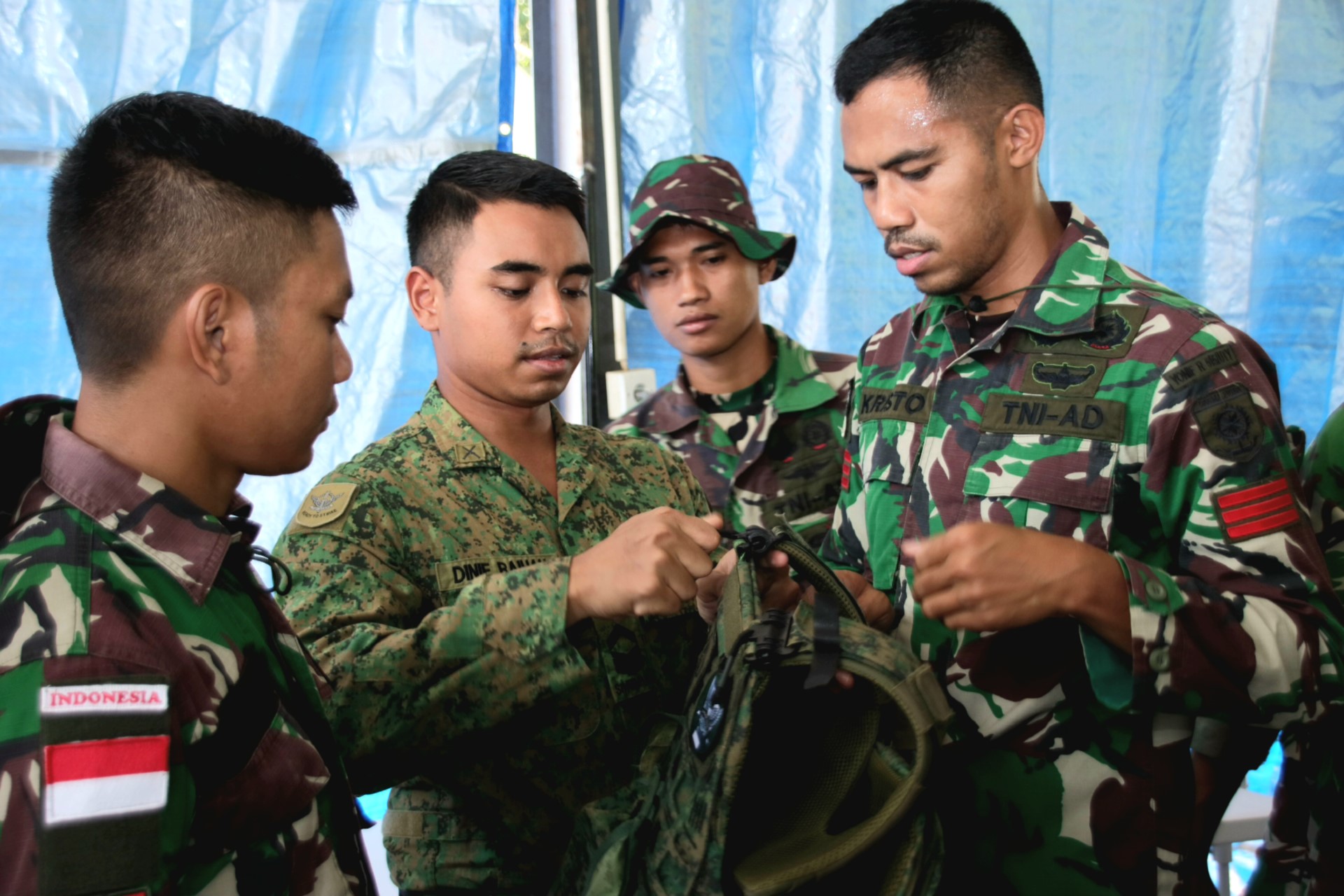Singapore and Indonesian Army personnel conducting a cross-sharing session of personal equipment.