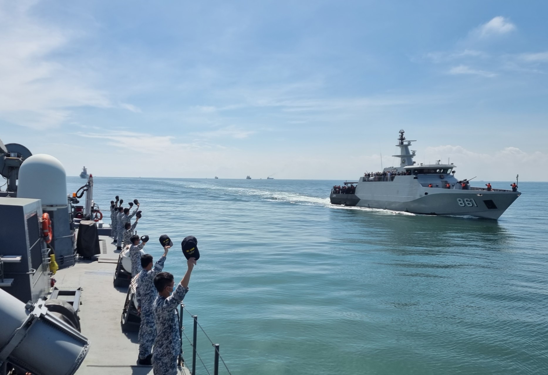 RSN personnel waving to representatives from participating countries on board KRI Lepu during an inspection of ships conducted after the opening ceremony of the ASEAN-Russia Maritime Exercise.
