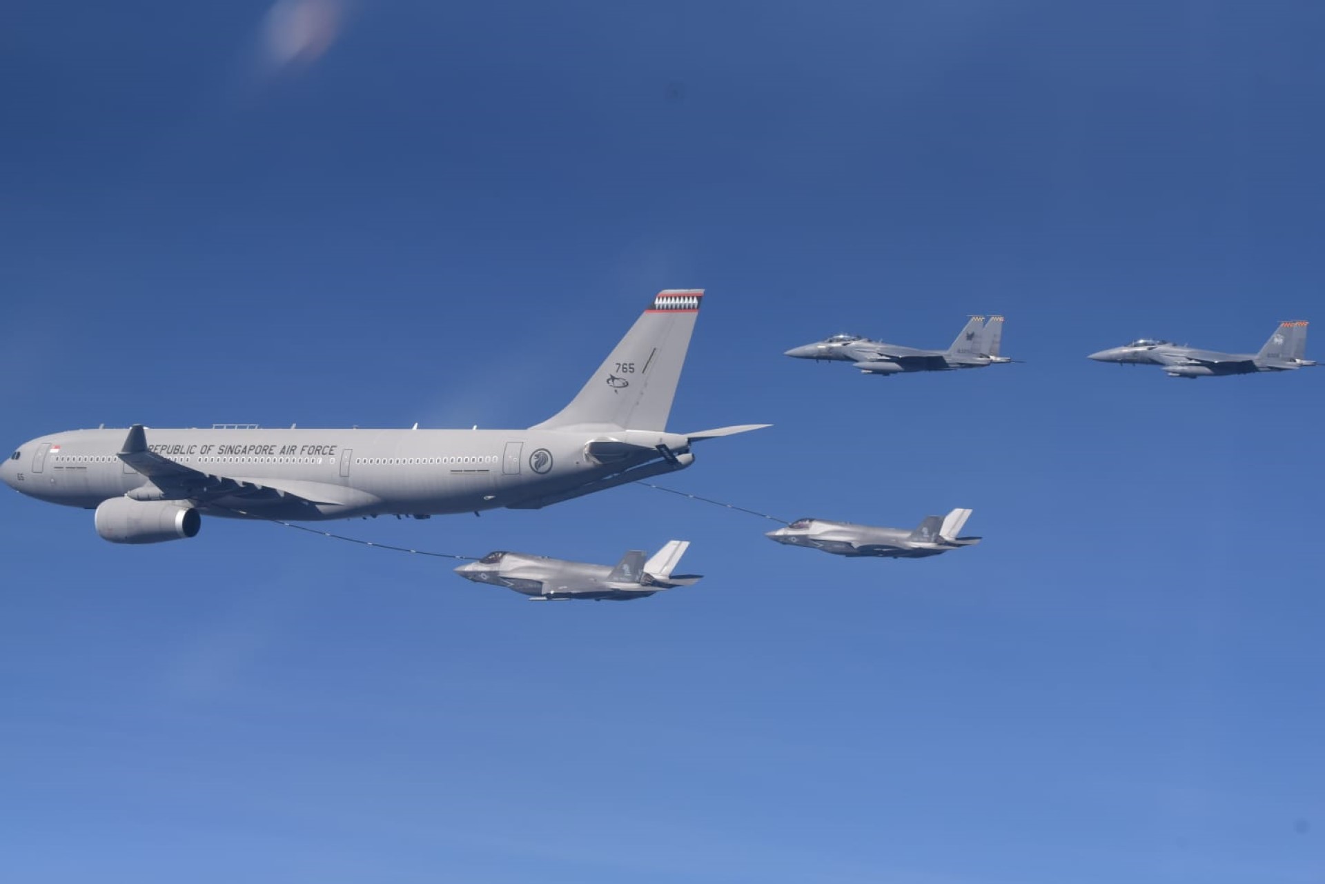 The Republic of Singapore Air Force's (RSAF) Multi-Role Tanker Transport conducting air-to-air refueling with two of the United States Marine Corps' F-35B fighter aircraft.
