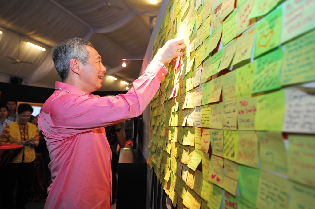 Prime Minister Lee Hsien Loong posting his thoughts on National Service on the NS45 Showcase board during the NS45 Commemoration Dinner.