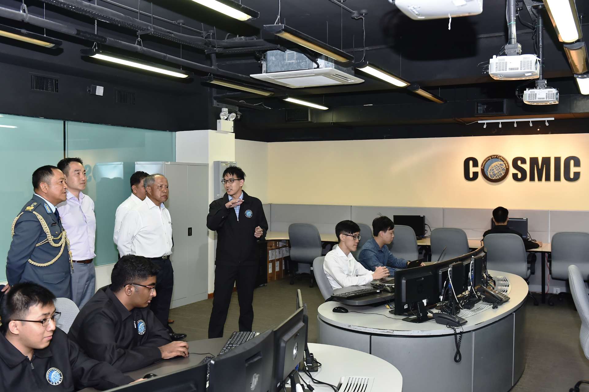 Pehin MG(Rtd) Halbi, accompanied by Director Military Security Brigadier-General Paul Chew, receiving a brief on the cyber security capabilities and operations of the Cybersecurity Operations, Sensing, Monitoring and Investigation Centre (COSMIC).