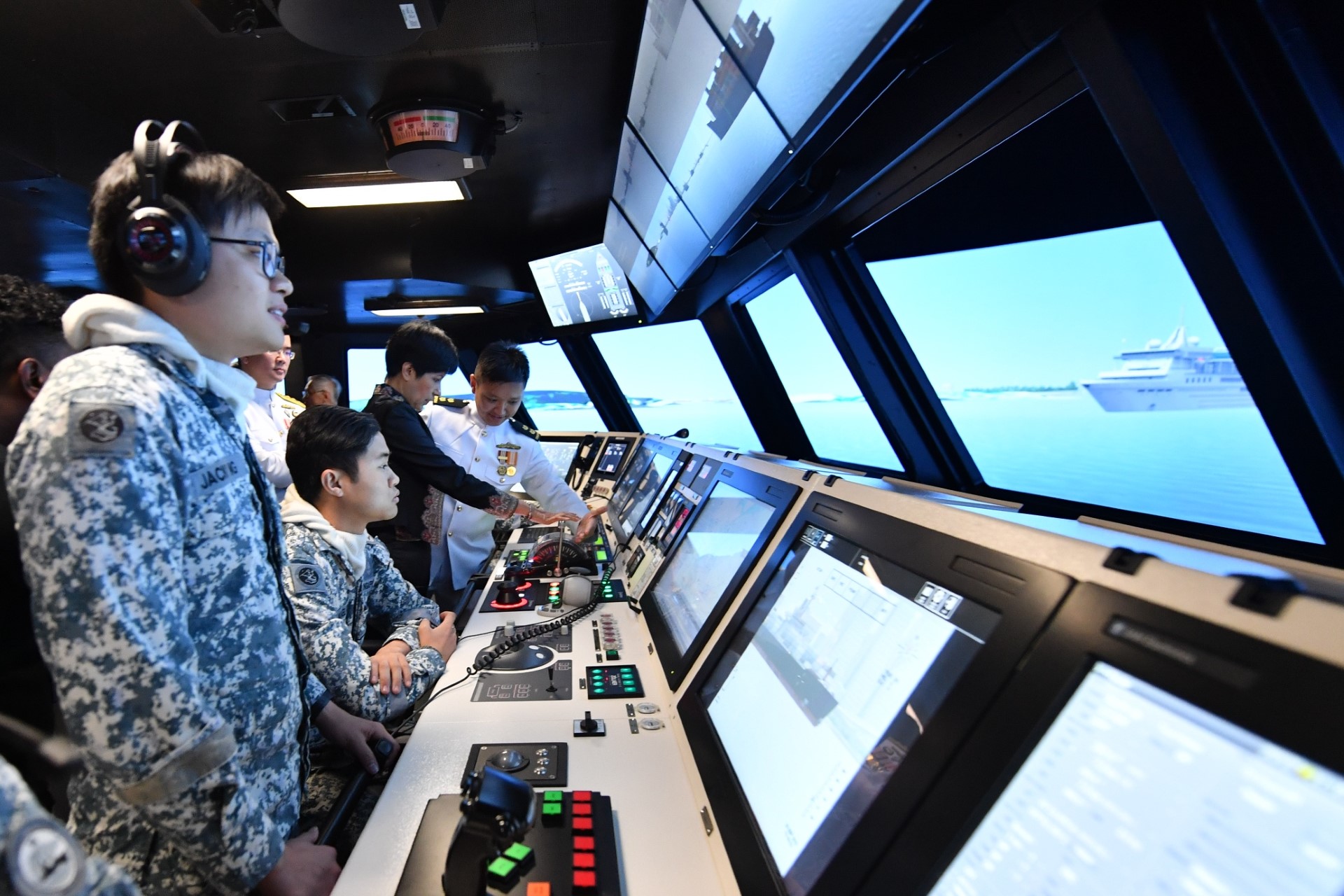 Ms Rajah pushing the ship's throttle in the simulation hall of RSS Daring - LMV Simulation Centre. 