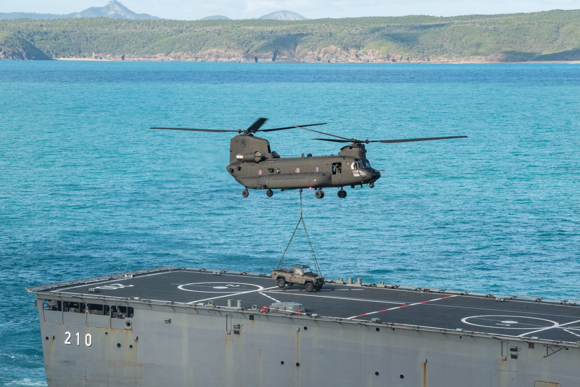 The RSAF's CH-47F Chinook helicopter lifting a land rover off RSS Endeavour during the replenishment serial as part of XWB21 held in the SWBTA.
