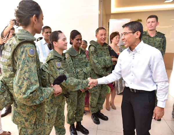 Minister of State for Defence Dr Mohamad Maliki Bin Osman (extreme right) interacting with the Singapore Armed Forces Volunteer Corps (SAFVC) Volunteers (SVs) after the Beret Presentation Parade.