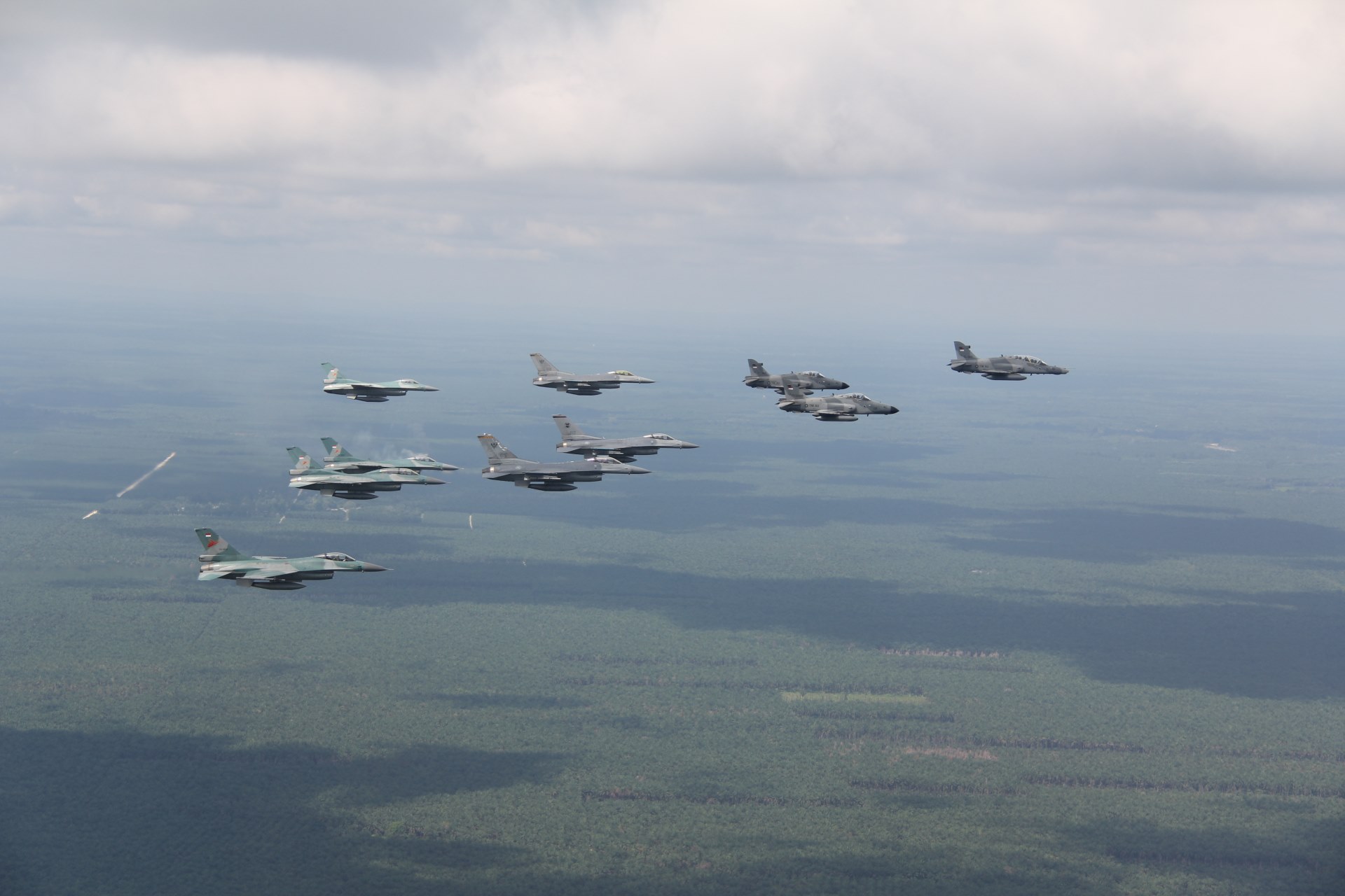 The Republic of Singapore Air Force (RSAF)'s F-16C and the Indonesian Air Force (TNI AU)'s F-16A/B and Hawk 109/209 flying in formation during Exercise Elang Indopura 2018.