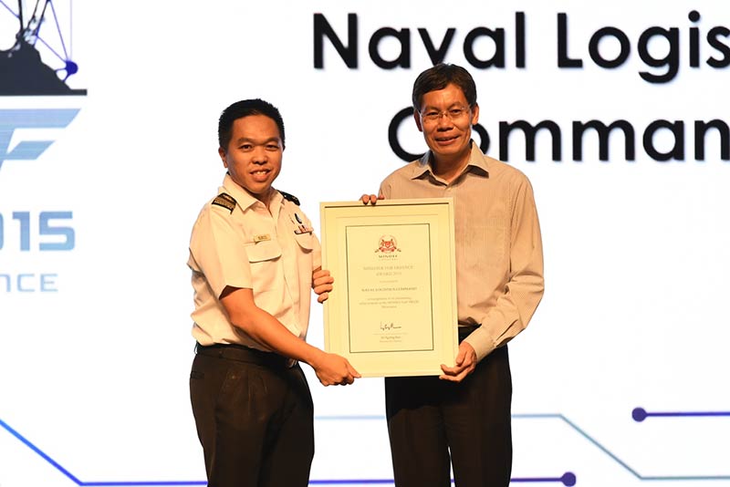 Mr Lui giving out the Minister for Defence Award to ME7 Andy Tay, Commander of the Naval Logistics Command (NALCOM).
