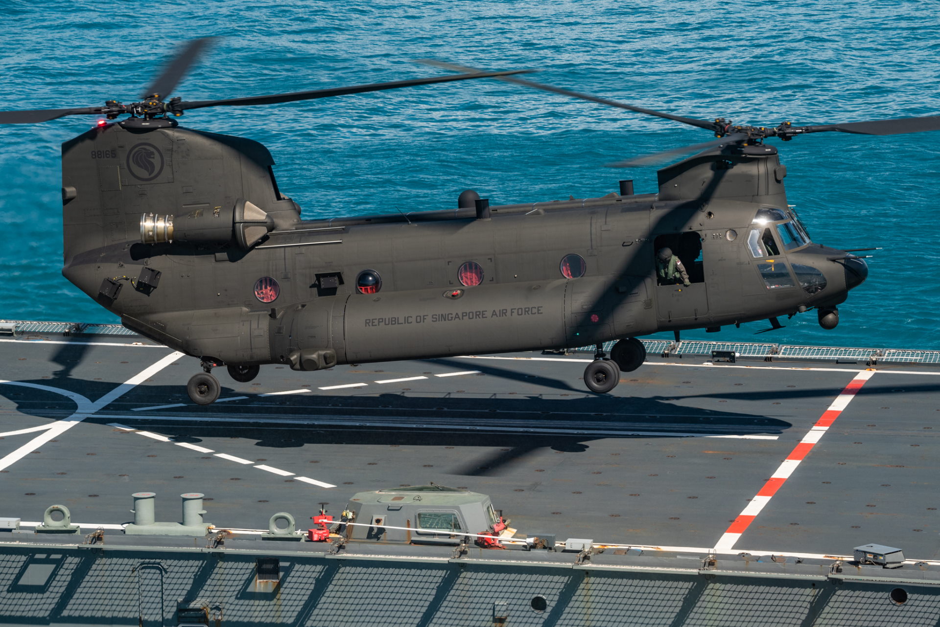 An RSAF CH-47F Chinook helicopter landing on the deck of the RSN's RSS Endeavour in the SWBTA, as part of deck-landing exercises during XWB21.
