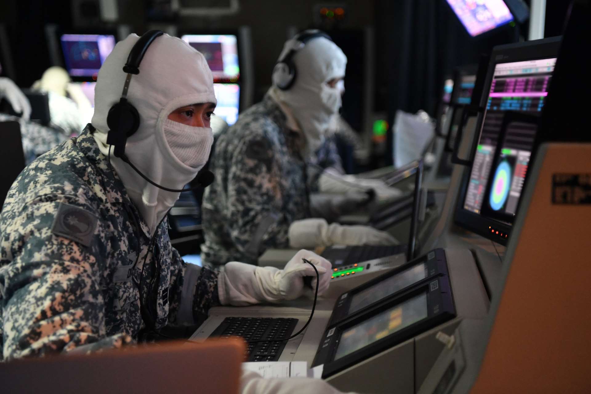 RSN personnel conducting a Simultaneous Time-on-Target Harpoon surface-to-surface live missile firing in the RSS Tenacious' Combat Information Centre.