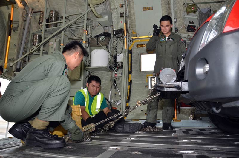 A vehicle being secured by RSAF Air Crew Specialists on board an RSAF C-130 aircraft.