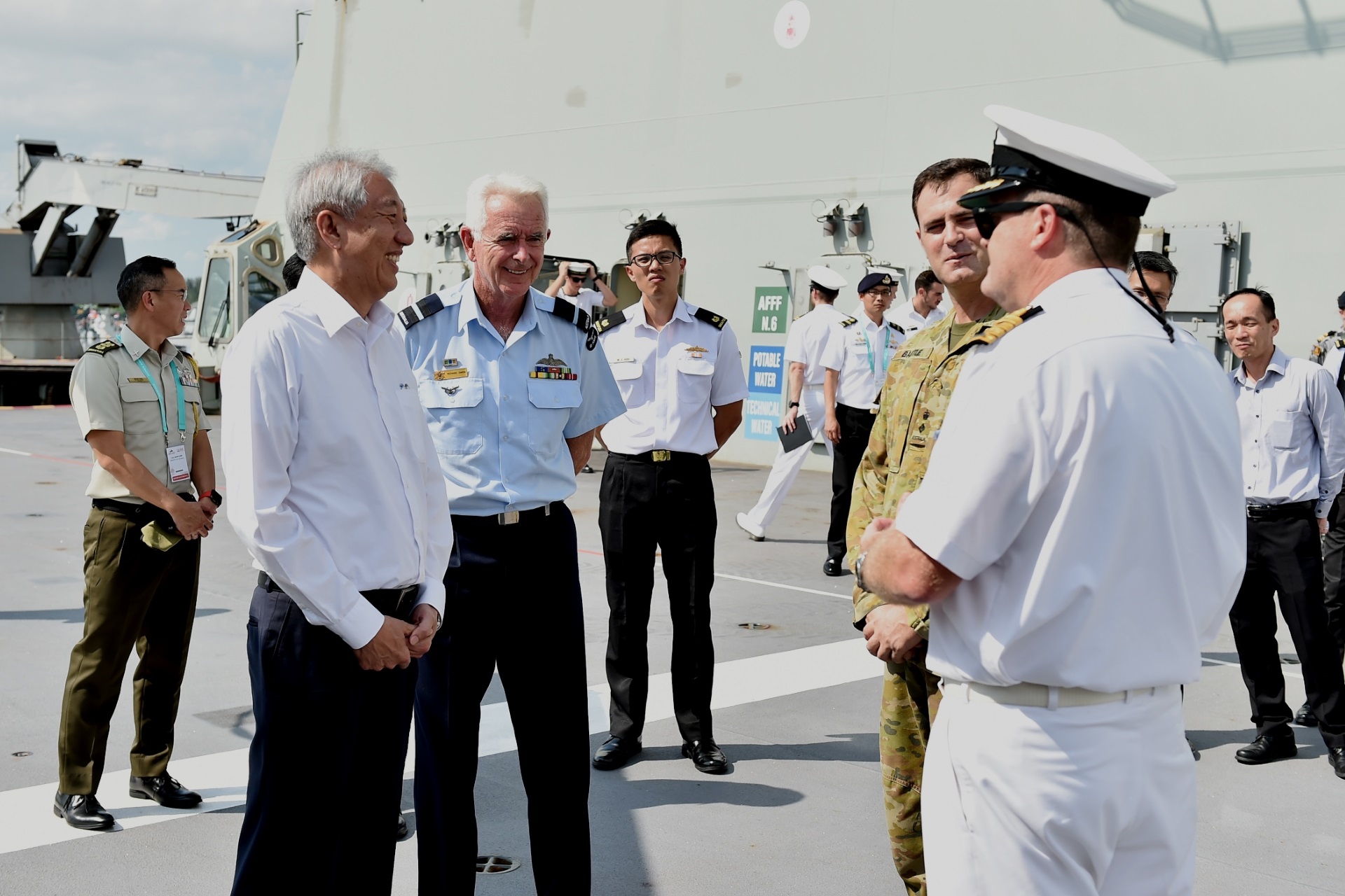 Senior Minister and Coordinating Minister for National Security Mr Teo Chee Hean interacting with personnel on the flight deck of Australian Navy ship, HMAS Canberra.