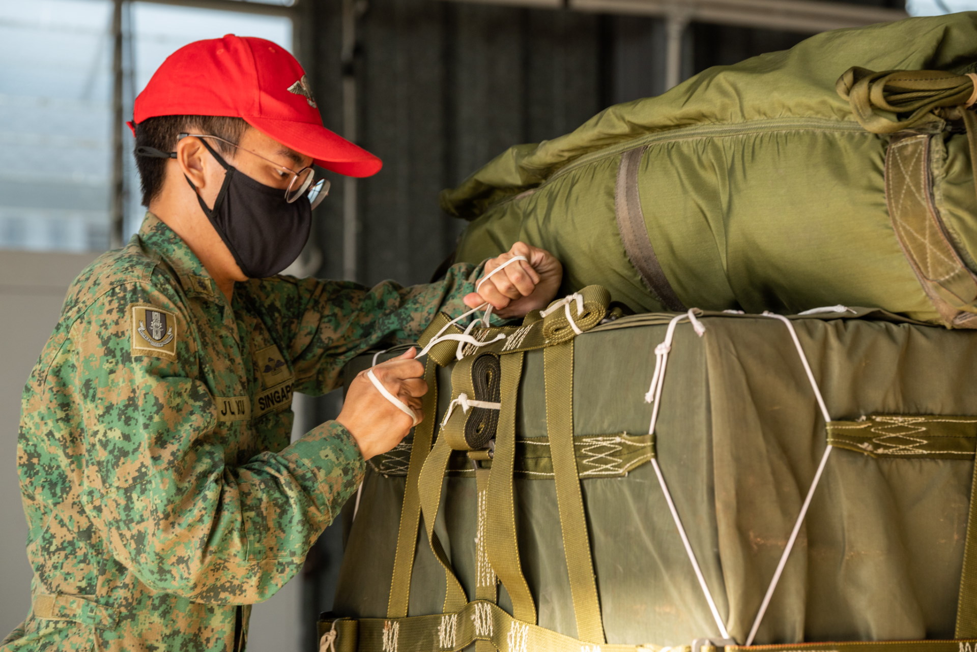 An Army personnel securing the parachutes to the packages prior to air-drop operations as part of XWB21.