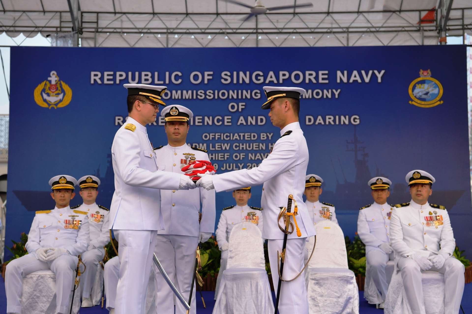 Commanding Officer RSS Resilience, Major Lee Pui Yau (front, right) presenting RSS Resilience's jack, ensigns and commissioning pennant to Chief of Navy Rear-Admiral Lew Chuen Hong (front, left) at the decommissioning ceremony.