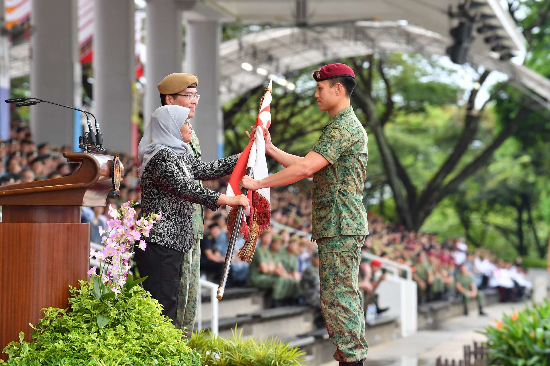 President Halimah presenting the State Colours to Lieutenant Colonel Ng Kiang Chuan, Commanding Officer of the 1st Commando Battalion which won the Best Combat Unit award.