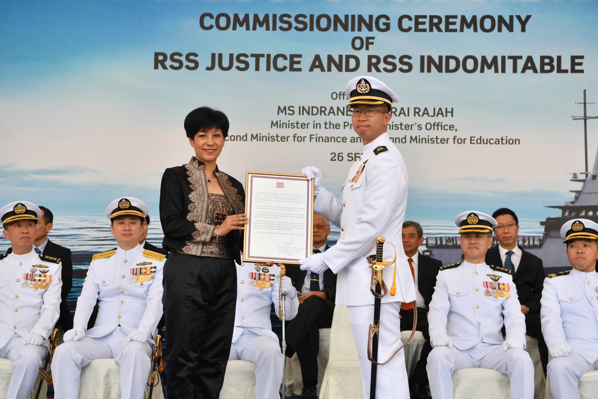 Ms Rajah presenting the Commissioning Warrant to the Commanding Officer of RSS Justice LTC Ye Yiming.