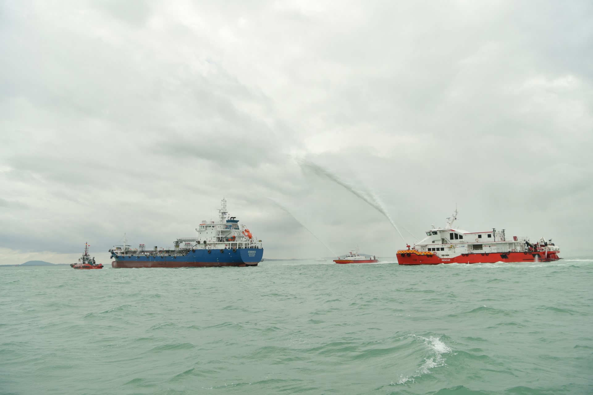 The Singapore Civil Defence Force's fire-fighting vessels are deployed to the scene to extinguish the simulated fire that broke out on board the 'hijacked' vessel.