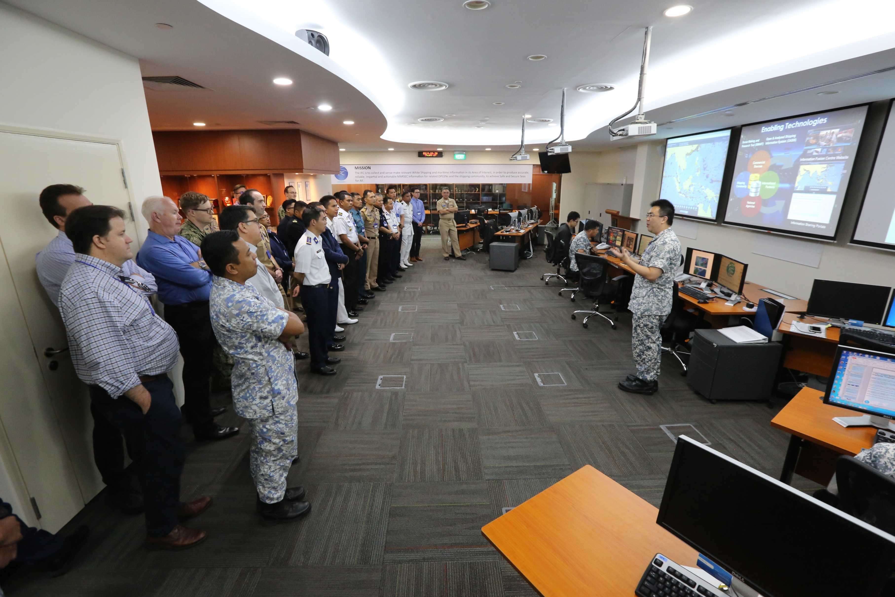 Exercise SEACAT participants receiving a brief on the newly enhanced information sharing portal at Republic of Singapore Navy (RSN)'s Information Fusion Centre.