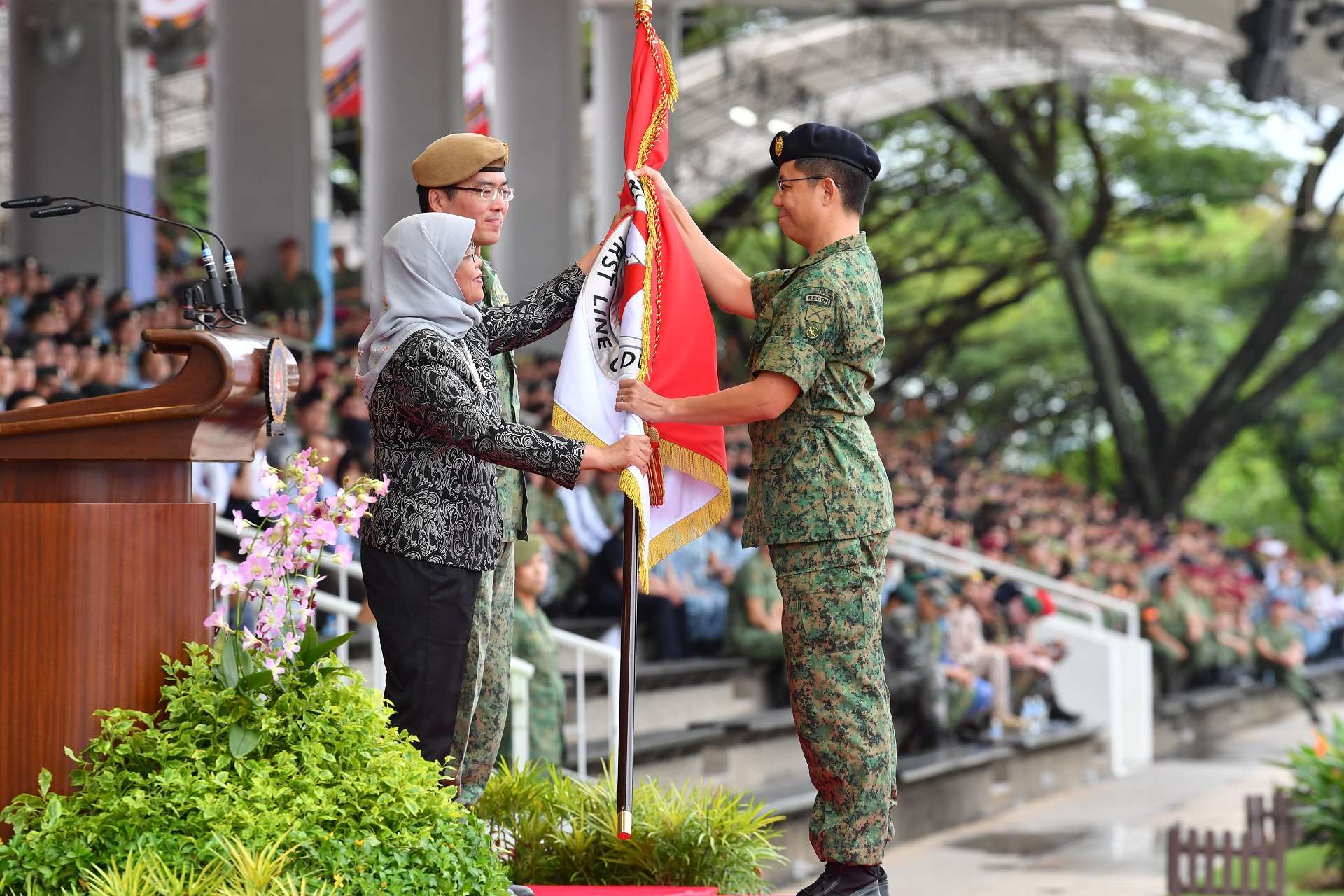 President Halimah presenting the new Regimental Colours to Headquarters Army Intelligence received by Chief Army Intelligence Officer Colonel Paul Cheak.
