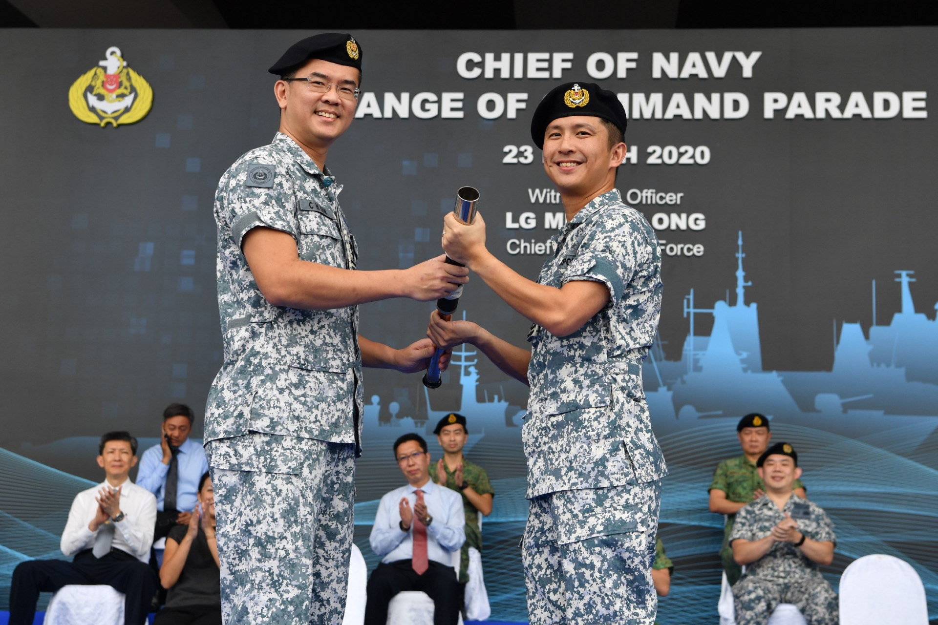 Outgoing Chief of Navy, RADM Lew (left), handing over the command symbol to incoming Chief of Navy, RADM Aaron Beng (right).