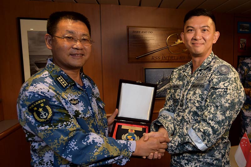 Commanders of the Task Groups for the exercise, the RSN's Colonel Ken Cheong (right) and the PLA(N)'s Senior Captain Zhang Ming Qiang (left), exchanging plaques during the Closing Ceremony onboard RSS Intrepid.
