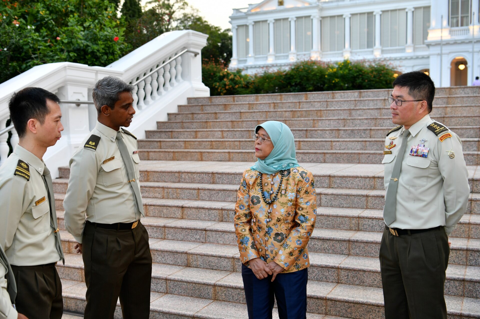 President Halimah (second from right) interacting with Major (NS) Navin Lobo Joseph (second from left) and other MINDEF/SAF personnel about their commitment to defence. 