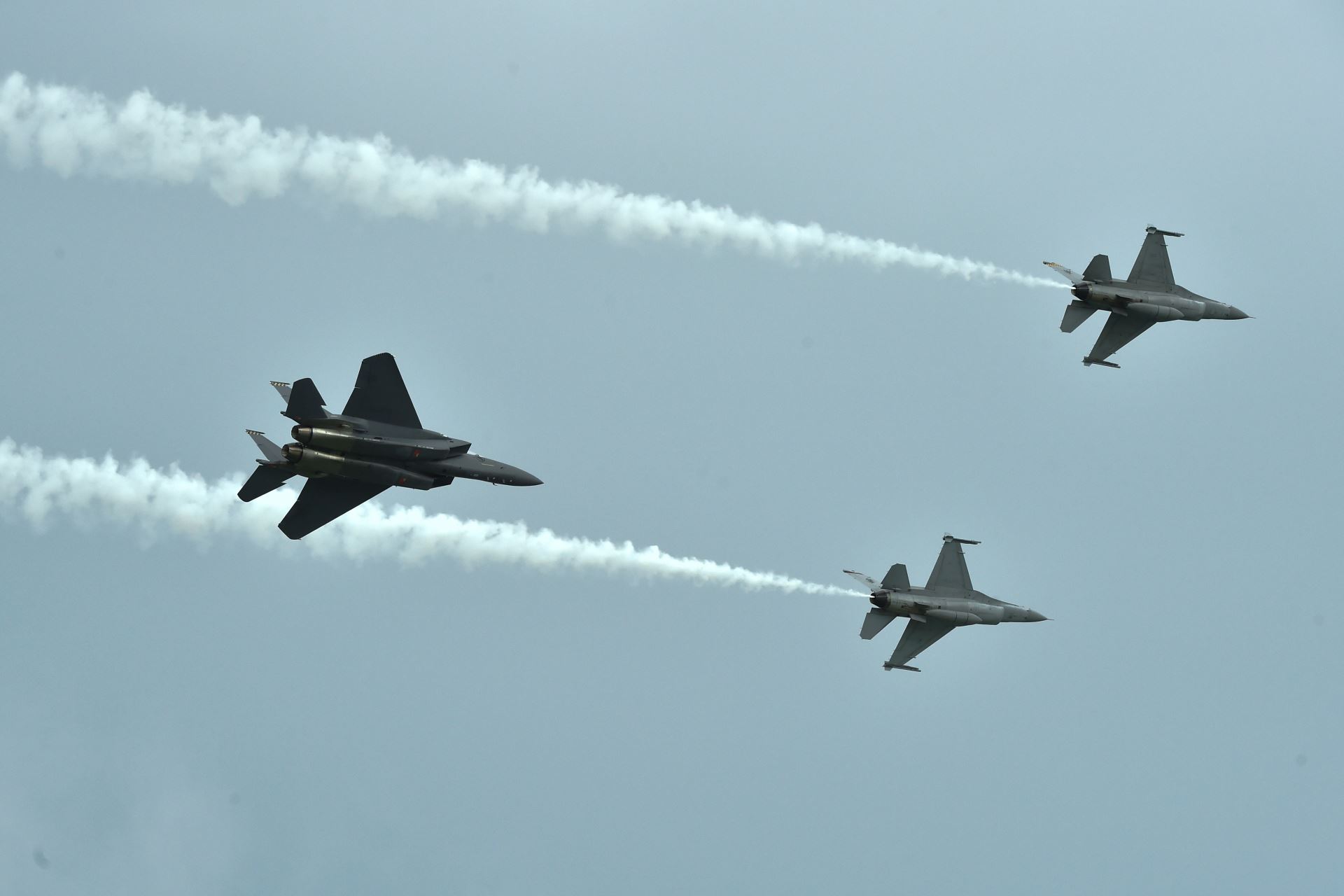 The F-15SG and F-16C fighter aircraft performing the ''3-Ship Barrel Roll'' as part of the RSAF's aerial display at SA18.