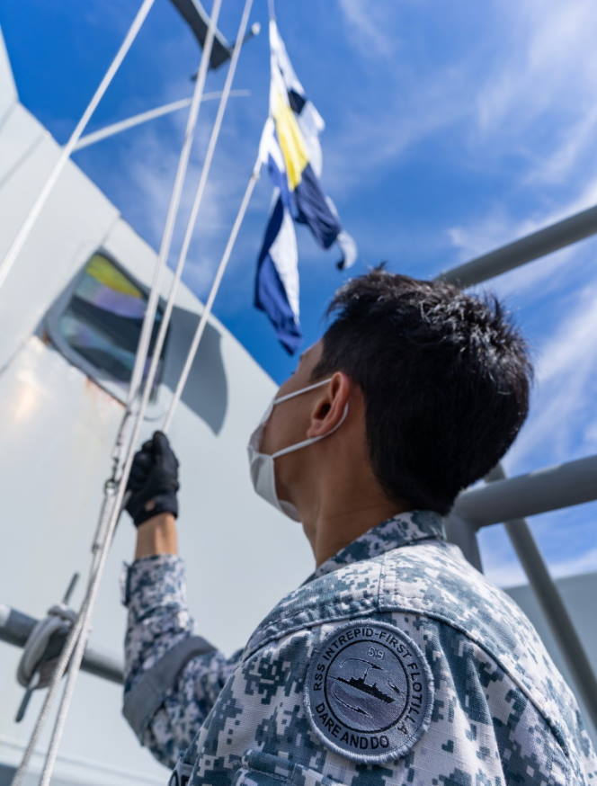 Naval flags being hoisted during a communication exercise.