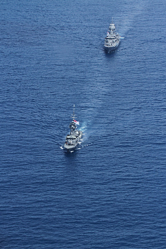 RSS Valour (foreground) and HMAS Arunta conducting naval manoeuvres.