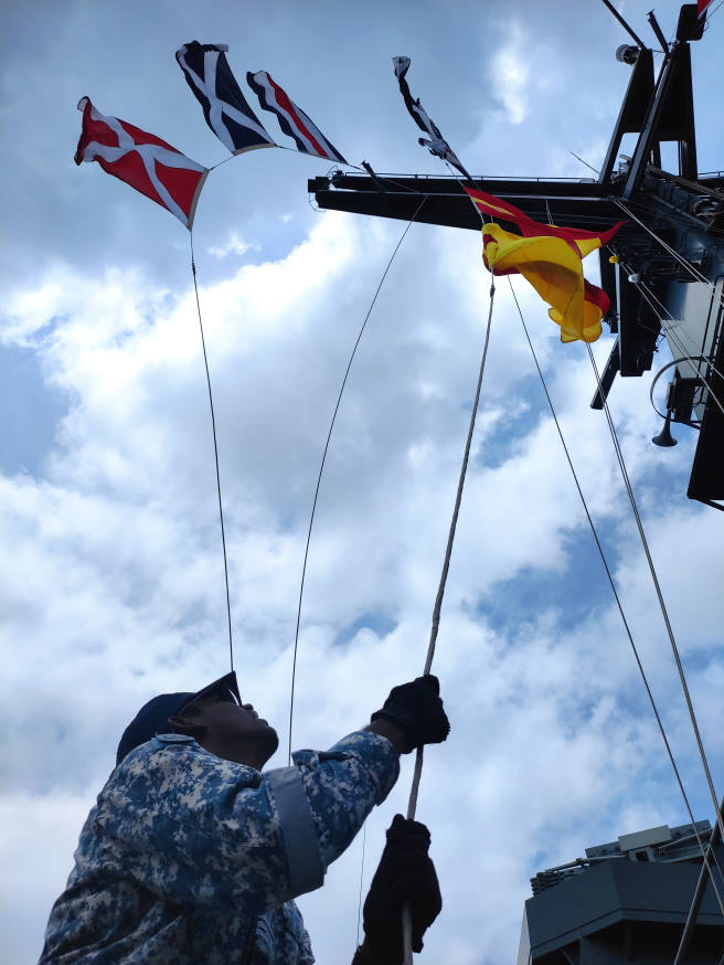 Exchange of messages conducted through the use of signal flags.