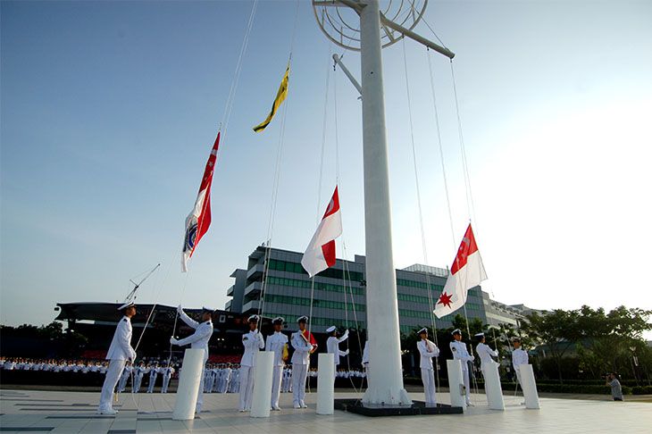 Navy soldiers raising the naval ensign