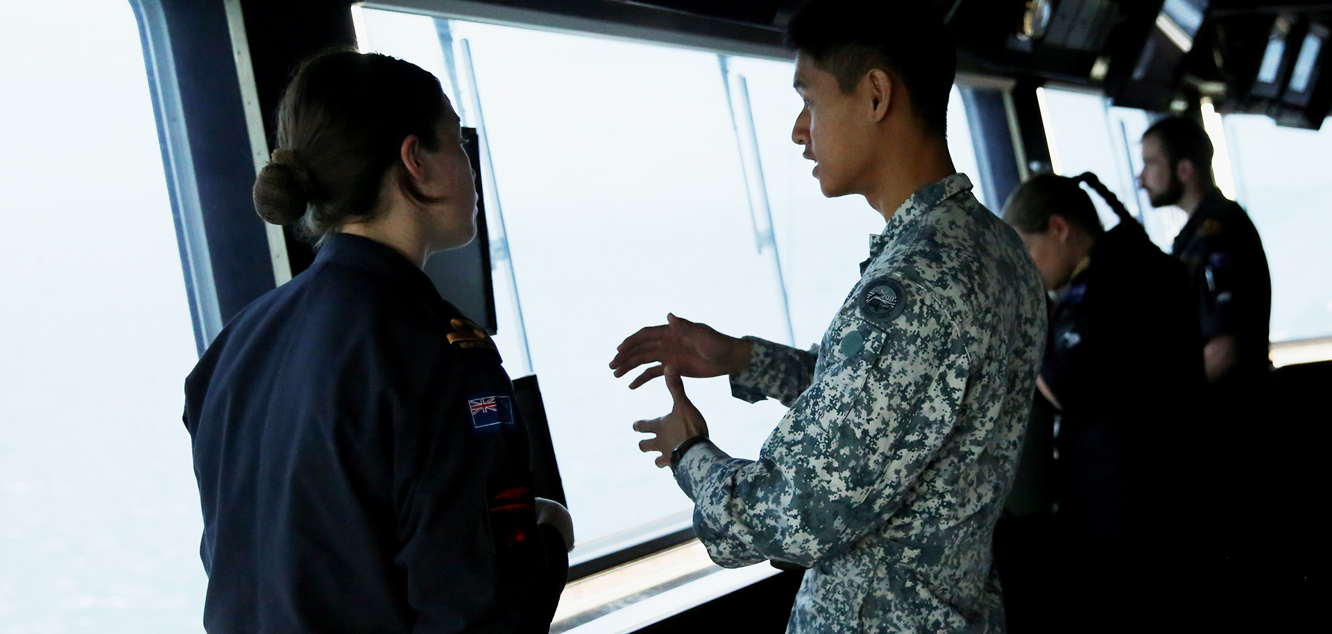 Singapore Navy personnel interacting with RNZN personnel on board RSS Resolution