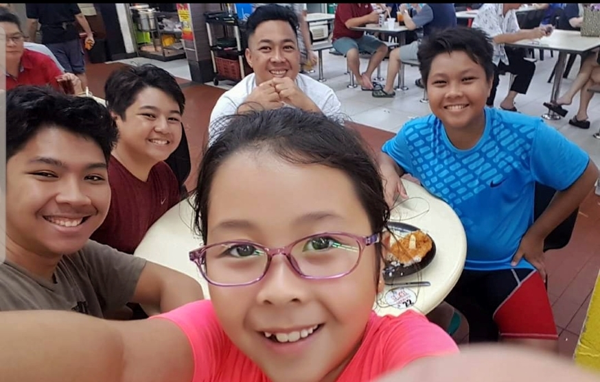 SV1 Nathaniel and his children enjoying a meal at the hawker centre.